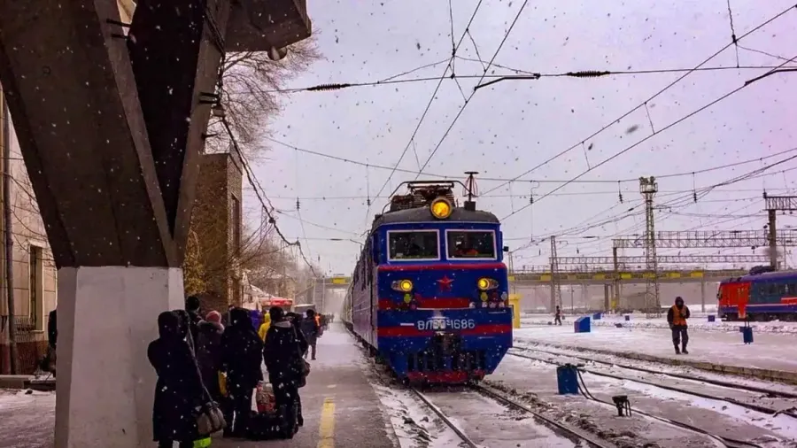 Tren transiberiano en una estación nevada con pasajeros en el andén