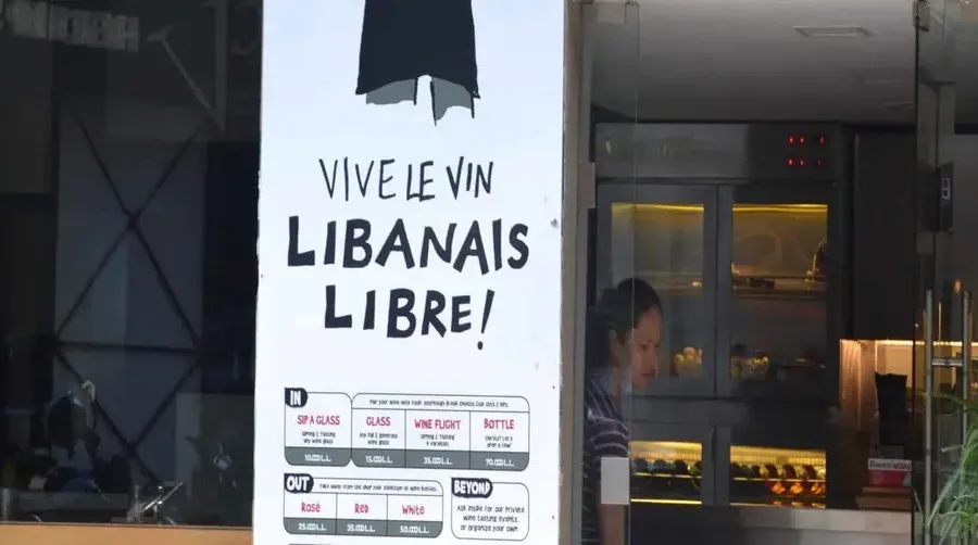 Cartel de un local con el texto «Vive le vin libanais libre»