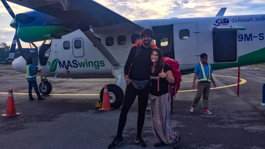 Pareja posando junto a una avioneta pequeña