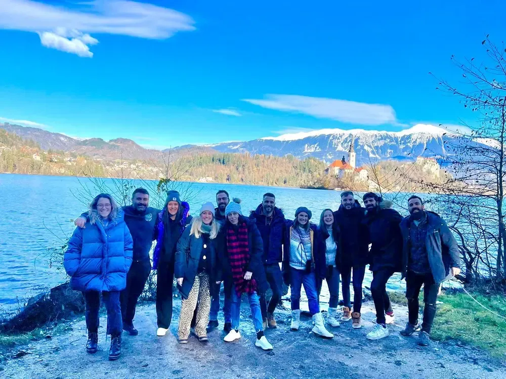 Grupo de viajeros junto al lago Bled con los Alpes Julianos al fondo