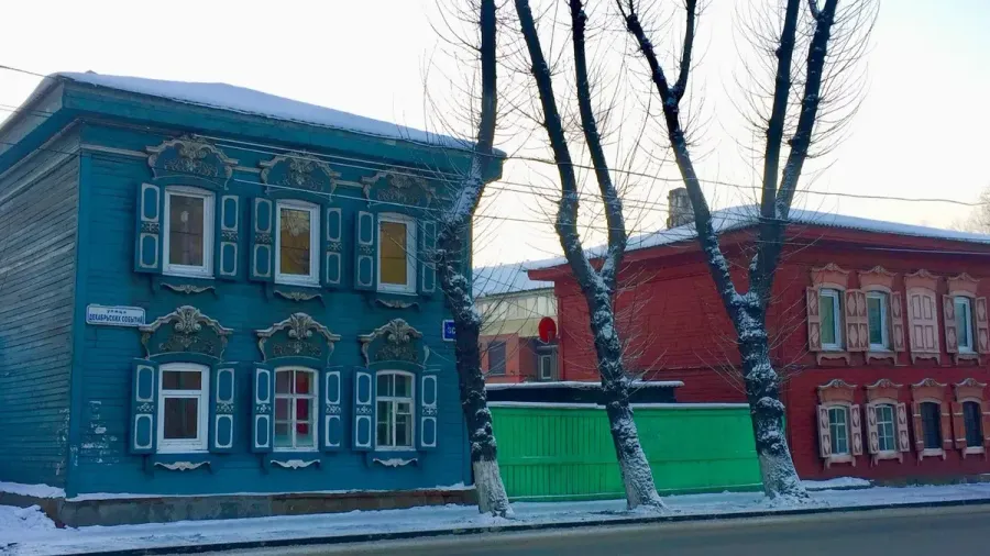 Casas de madera tradicionales azul y roja con nieve en Irkutsk