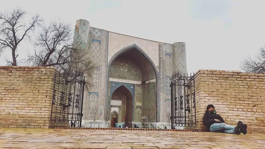 Fachada de una madraza con una persona sentada en la puerta