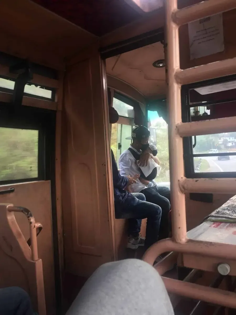Hombre cuidando de su bebé en el autobús. La mamá está sentada charlando. Es muy normal esta imagen que choca con el resto de India
