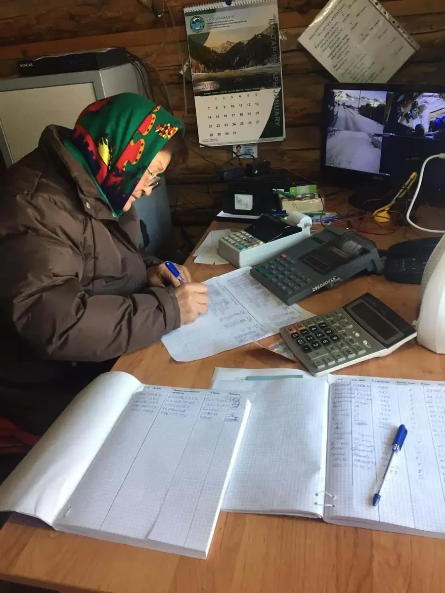 Señora cobrando los tickets para entrar al lago