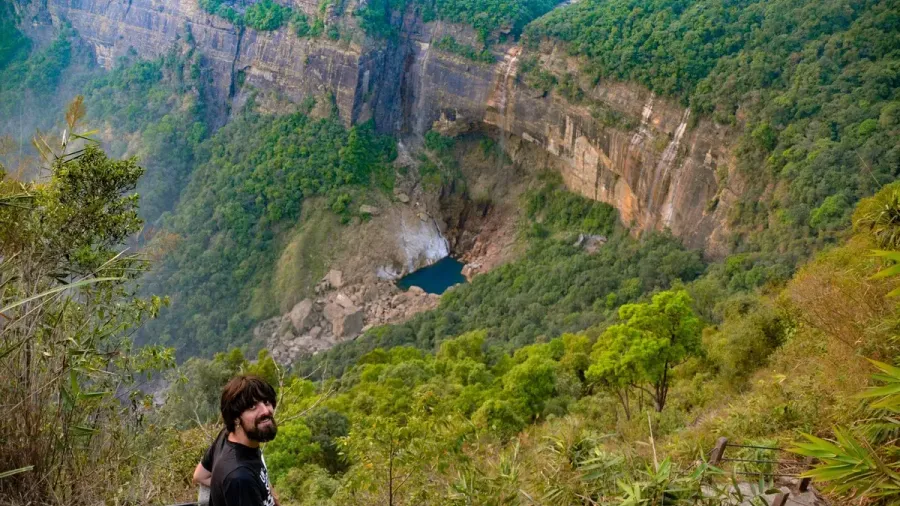 Viajero en un mirador sobre los acantilados verdes de Meghalaya