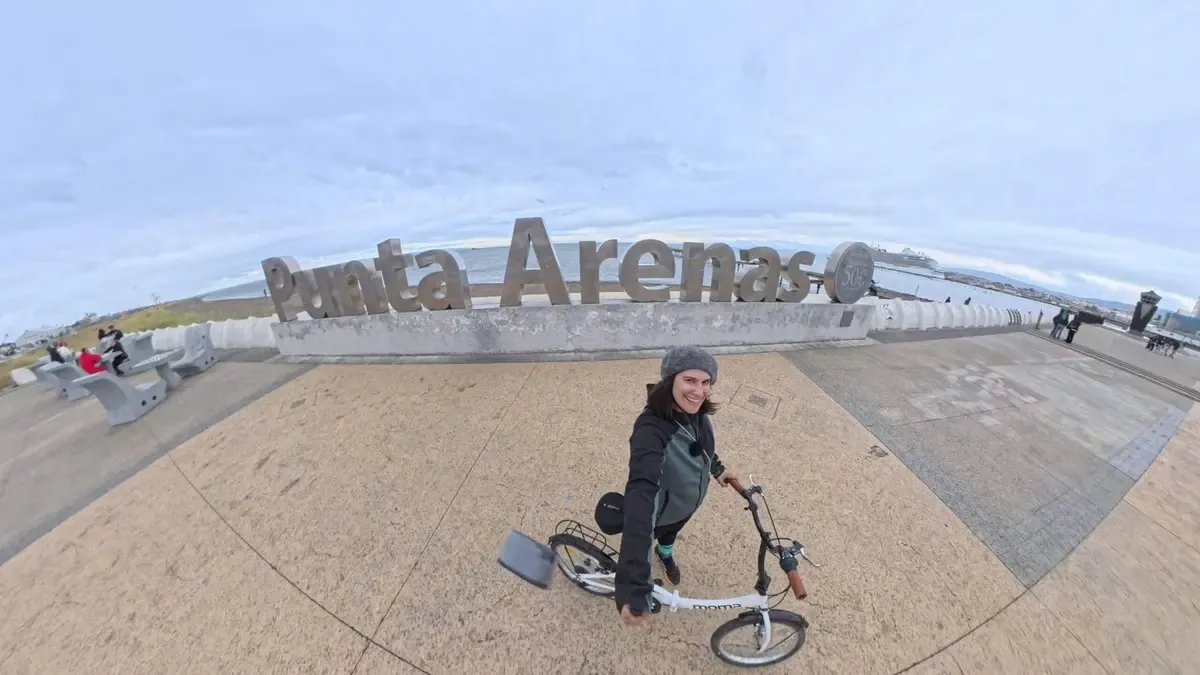 Cris en bicicleta frente al cartel de Punta Arenas