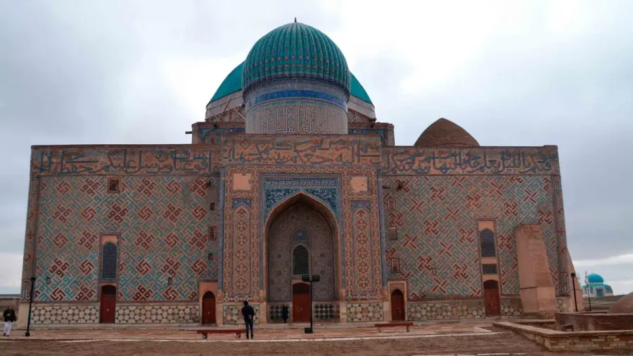 Mausoleo con cúpula turquesa y fachada de azulejos en Kazajistán