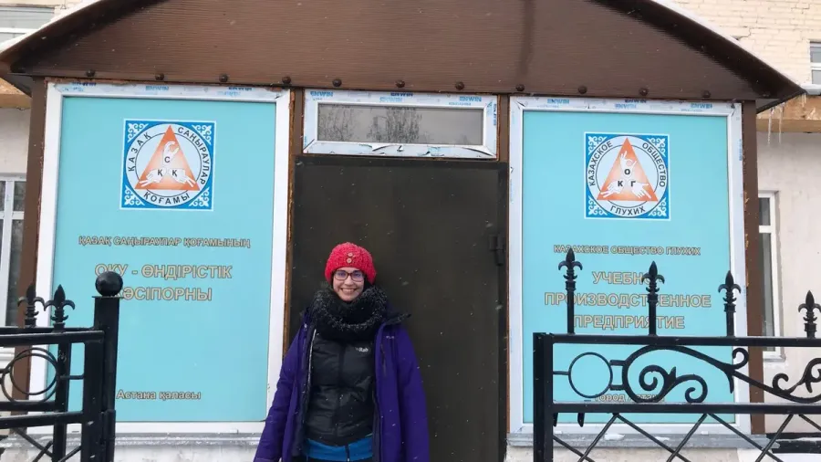 Viajera abrigada frente a la puerta del edificio de la Sociedad de Sordos de Astana