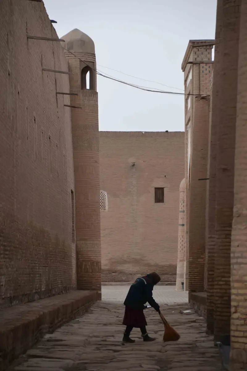 Mujer barriendo la calle en Khiva