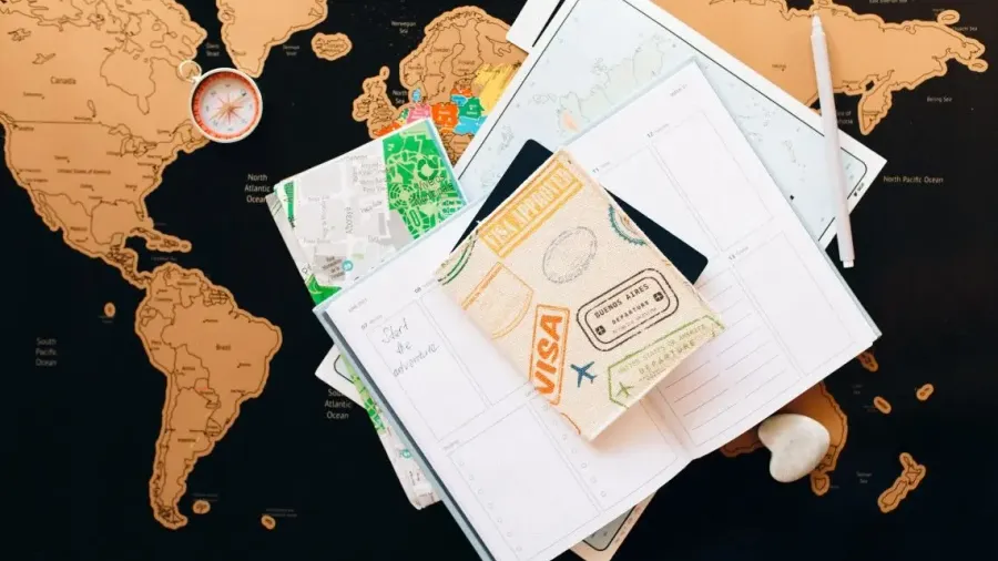 Mapa del mundo con pasaportes, sellos y visados sobre una mesa